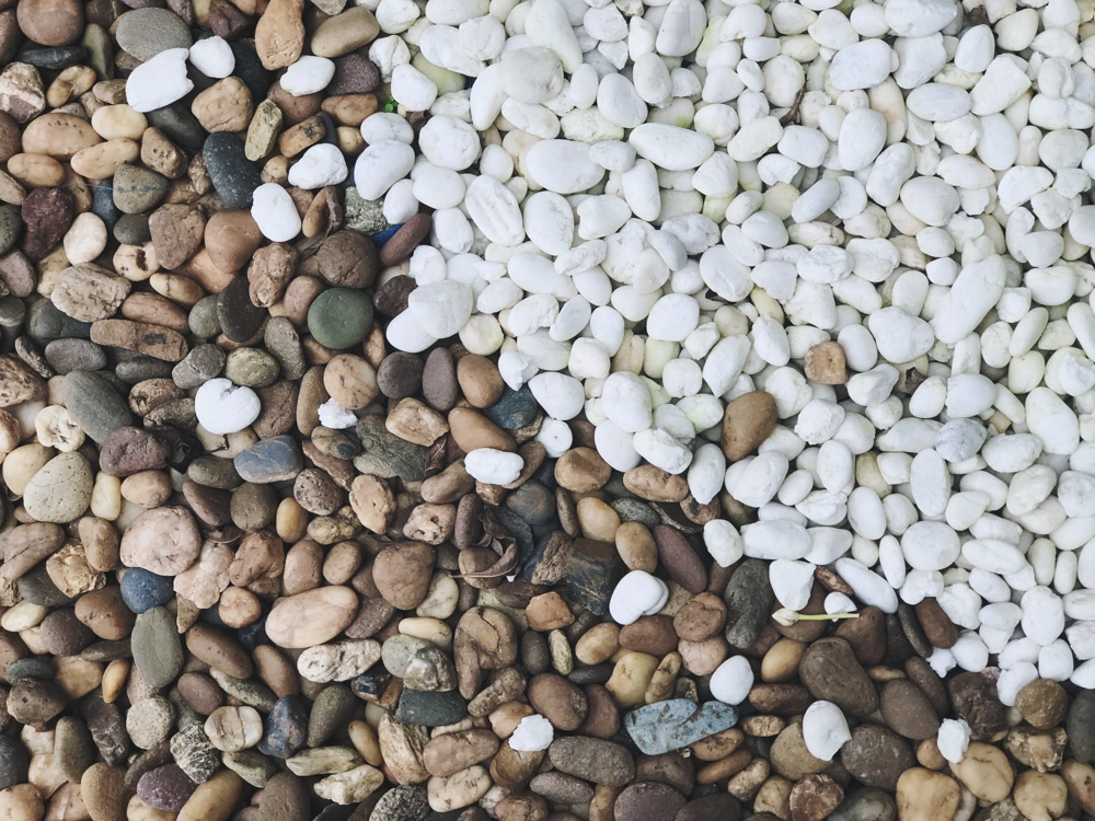 Biało-brązowa mieszanka gładkich kamieni ułożonych w dwóch kolorach Kamienie ozdobne