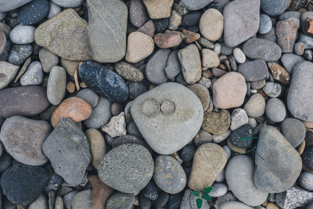 Dwie srebrne obrączki na szaro-beżowych kamieniach ozdobnych